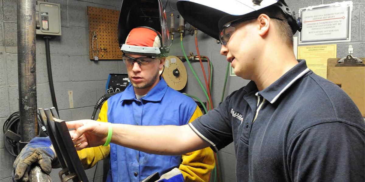 协会的 welding student receives instruction.