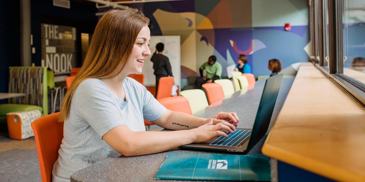 Student using computer on AACC campus.